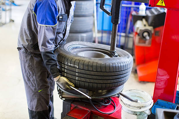 Auto mechanic is changin tire...prepairing car for winter