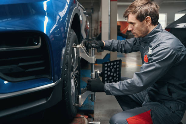 Male inspecting wheel alignment in the workshop