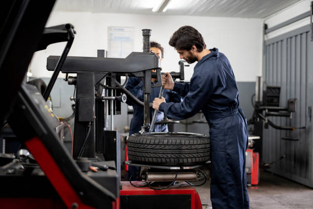 Team of mechanics at an autorepair shop fixing a punctured tire