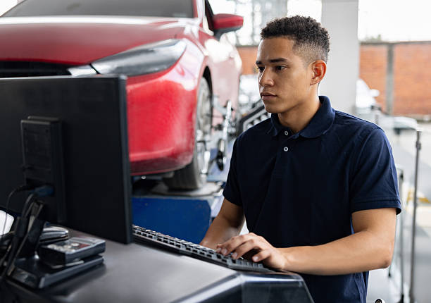 Latin American mechanic using scanner to fix a car at a garage